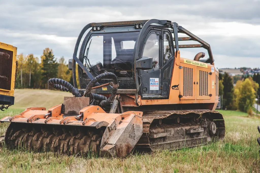 En bulldoser står parkert på et jorde, klar for stubbesliping.