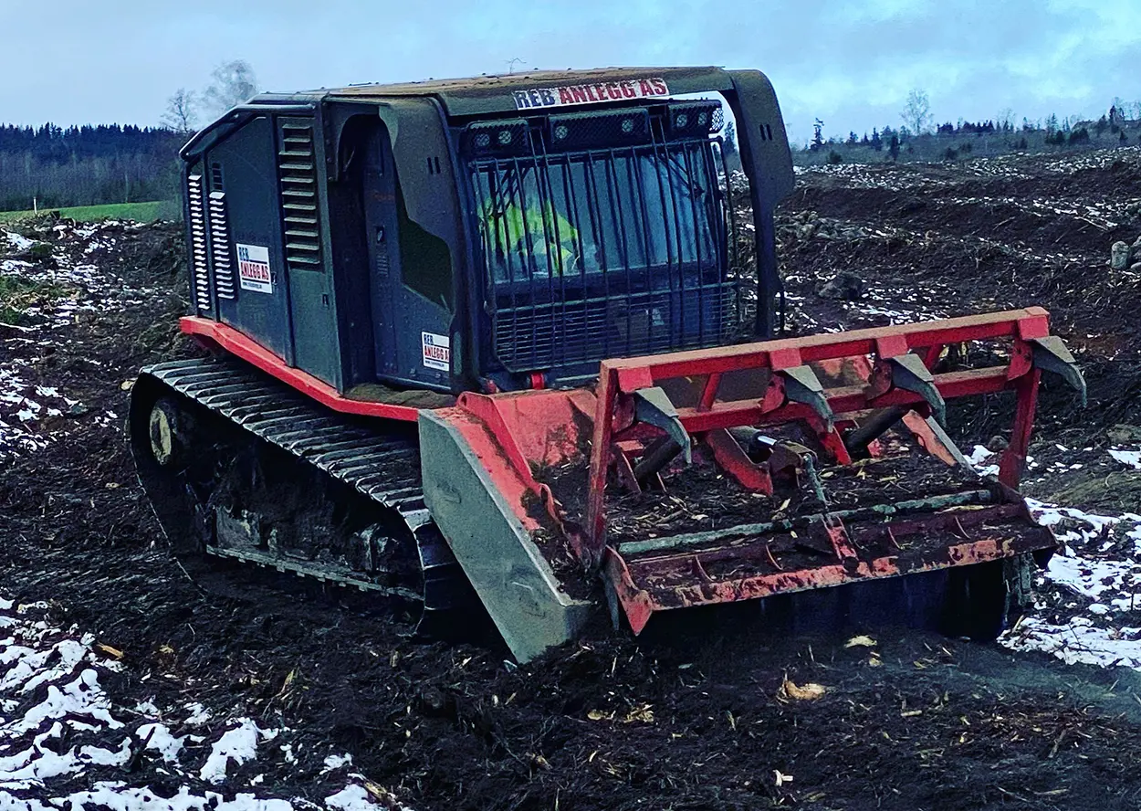 En rød og svart bulldoser i et snødekt felt i Tyskland.