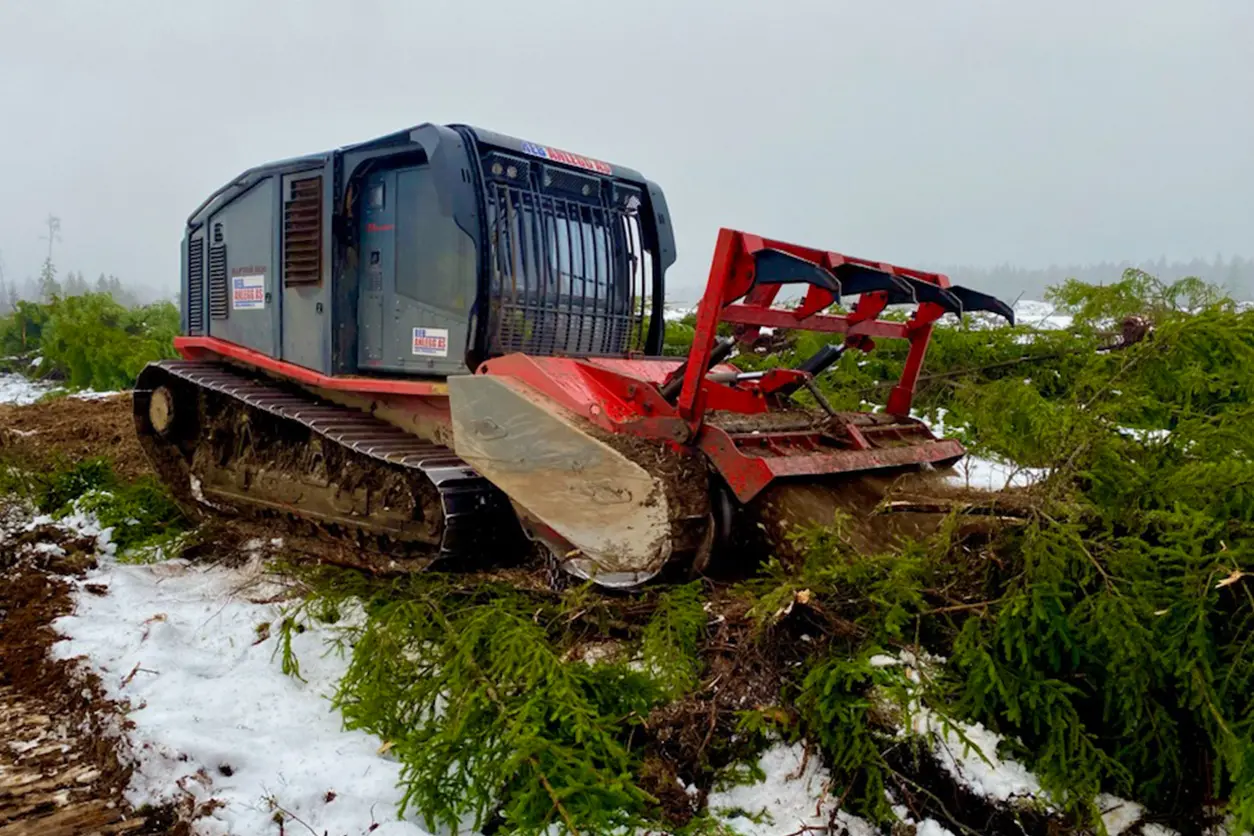 En rød og svart bulldoser på et snødekt jorde ved Seierstad gård.