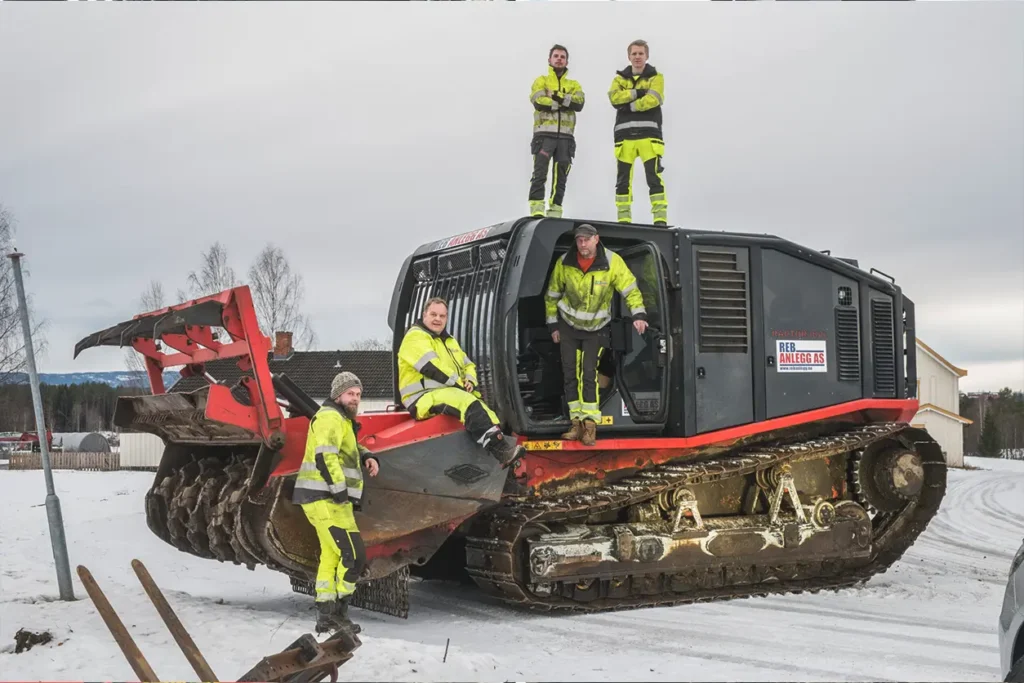 En gruppe menn som står på toppen av en bulldoser under reb anlegg.