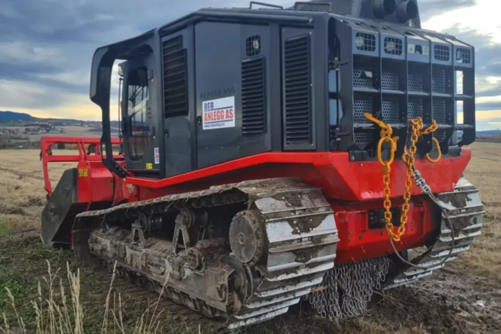 En rød bulldoser på et felt.