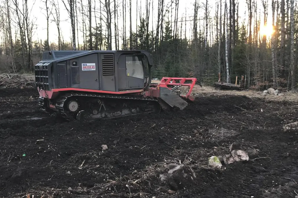 En bulldoser rydder et skogsområde for bygging.