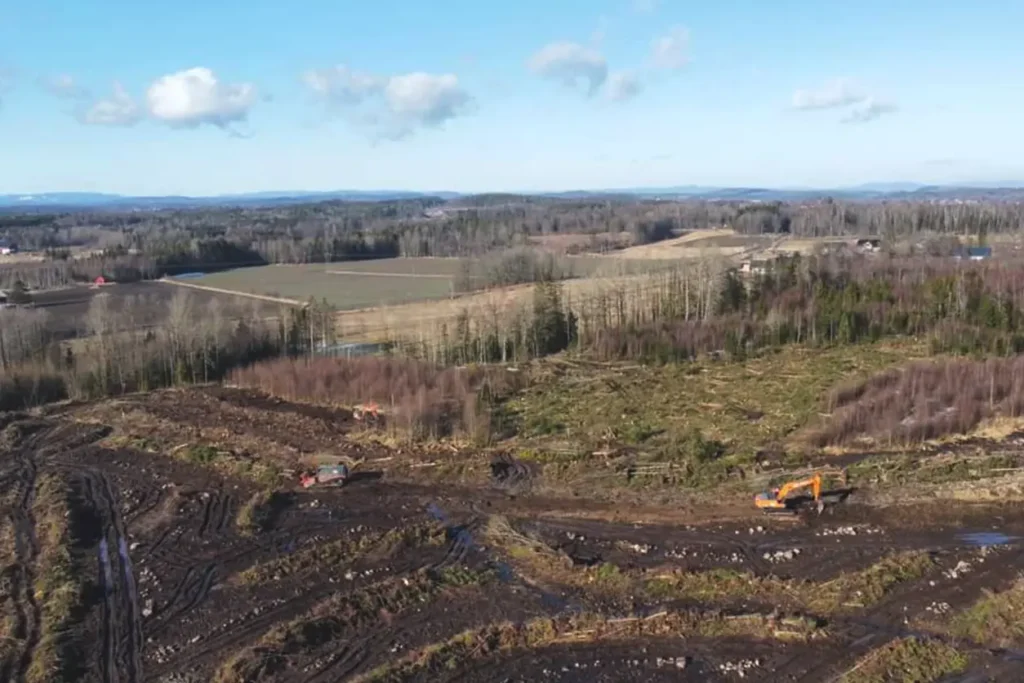 Et luftfoto av et felt med en bulldoser i bakgrunnen, som viser det imponerende byggearbeidet som utføres av dyktige arbeidere.